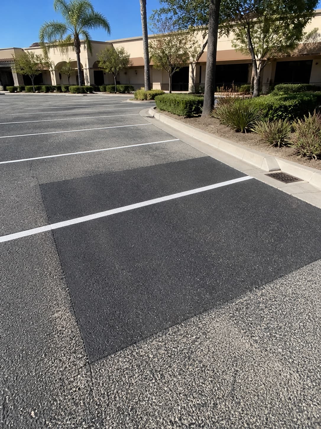Illustrative iPhone-style view of a completed asphalt repair in a Southern California commercial parking lot