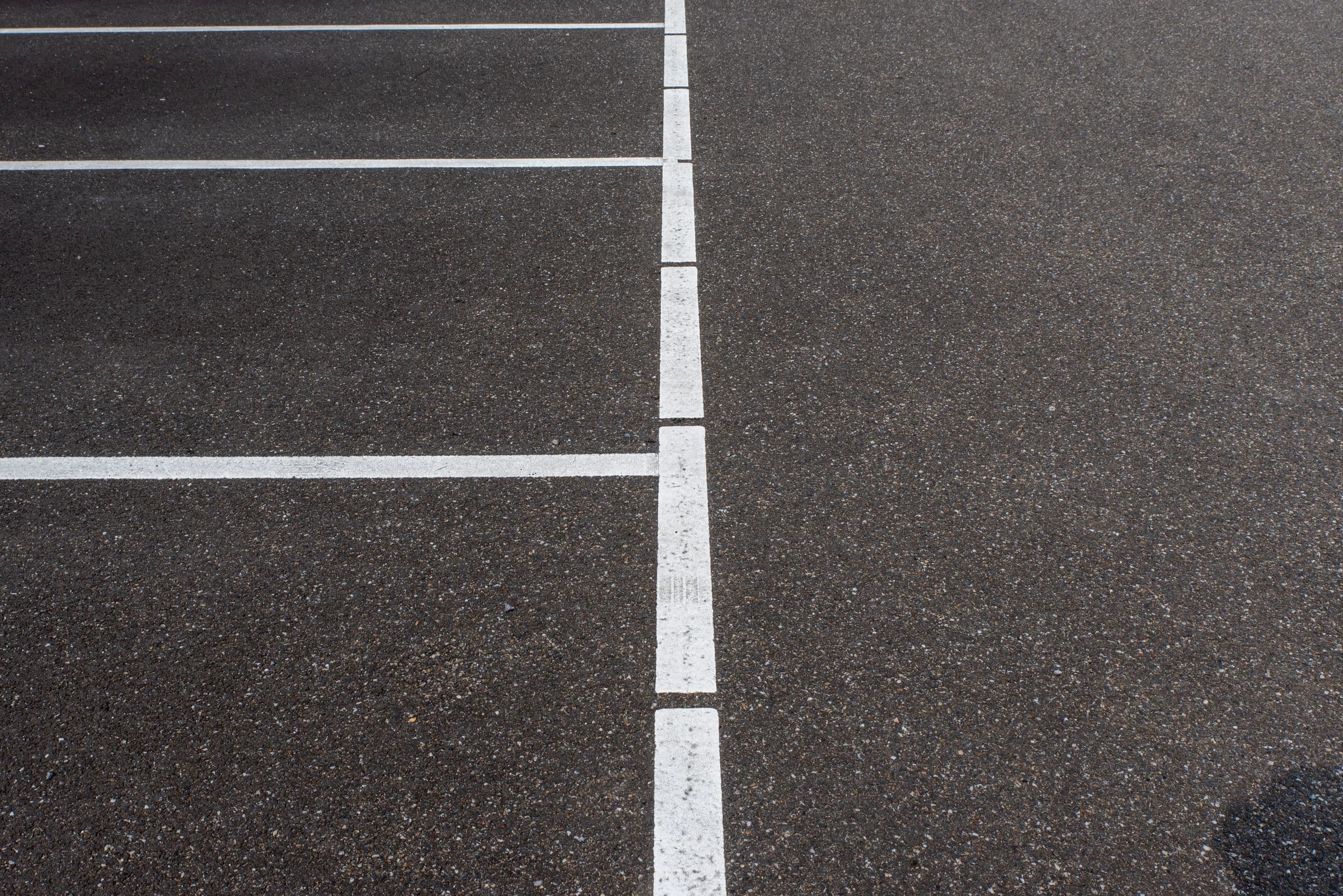 Real photograph of parking-space linework on asphalt